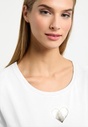 Witte t-shirt met korte mouwen met een metallic gouden hartontwerp op de borst. Zachte stof met een ronde halslijn en een gladde textuur.