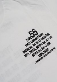 Tessuto bianco con testo nero contenente specifiche, tra cui "TIPO 55," "100% BASICO," e "CONTRACTOR DIESEL INDUSTRY INC." in un font standard.