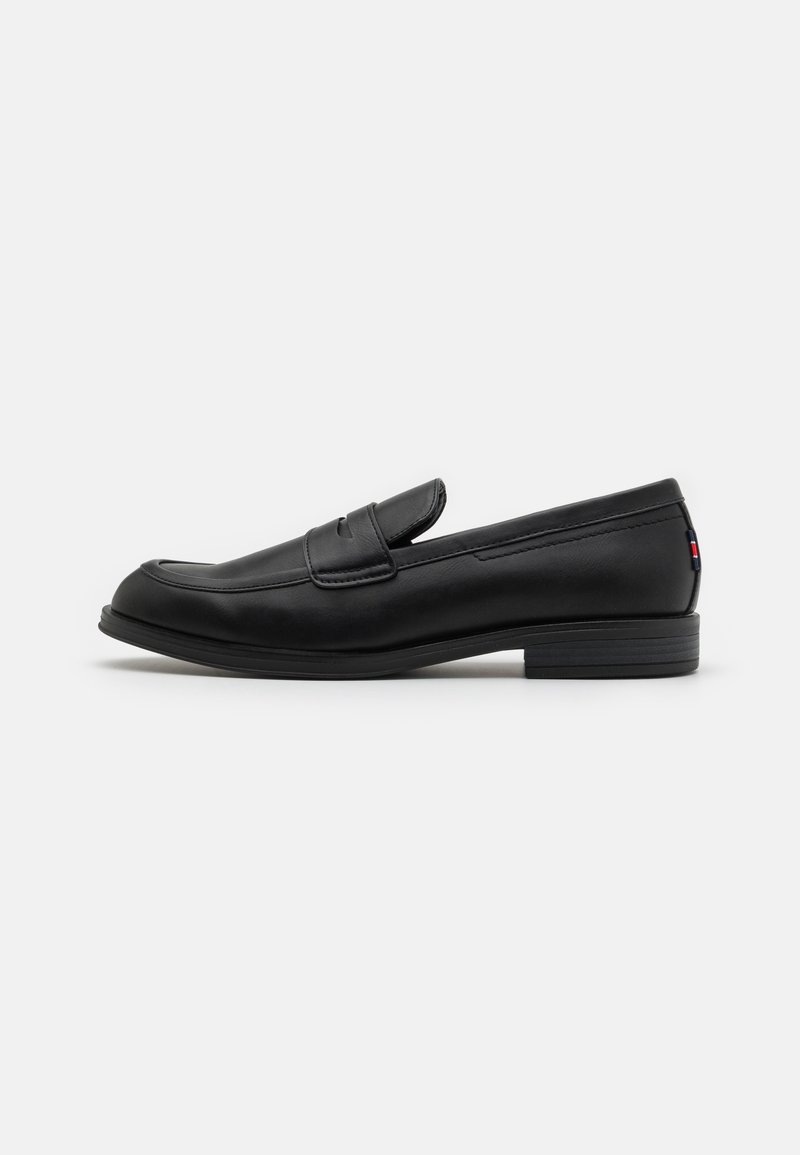 Black leather loafers with a smooth finish, rounded toe, and a small decorative flap. Features a low stacked heel and subtle branding detail.