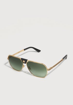 Gold-gerahmte Aviator-Sonnenbrille mit grünen Verlaufsgläsern, schwarzer Nasenbrücke mit goldenem Emblem und schwarzen Bügelenden mit dekorativem Muster.
