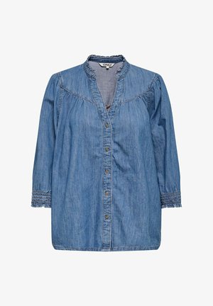 Vaaleansininen farkkupaita, jossa on nappisuljenta edessä, kootut yksityiskohdat ja joustavat hihansuut. Varustettu kauluksessa ja pehmeässä tekstuurissa.