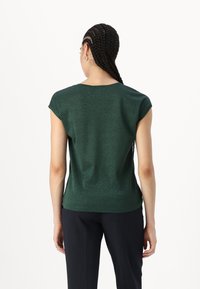 Dark green, short-sleeved top with a soft, shiny texture. Round neckline and a relaxed fit, paired with tailored dark pants.