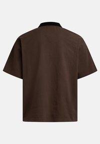 Brown short-sleeve polo shirt, featuring a black collar and soft cotton material. Simple design with a relaxed fit and no visible patterns.