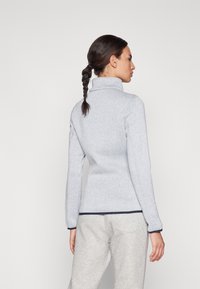 Pull unicolore gris clair à manches longues avec col montant. Présente une texture côtelée et des accents bleu marine aux poignets et à l'ourlet. Design ajusté.