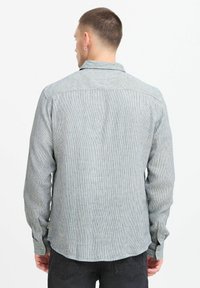 Gray and white striped long-sleeve shirt with a collar, buttoned cuffs, and a curved hem. Made of a lightweight fabric with a textured finish.