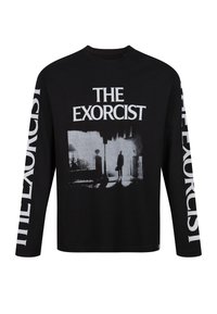 Svart långärmad t-shirt med en stor grå grafik från "The Exorcist" på framsidan och fet vit text längs ärmarna.