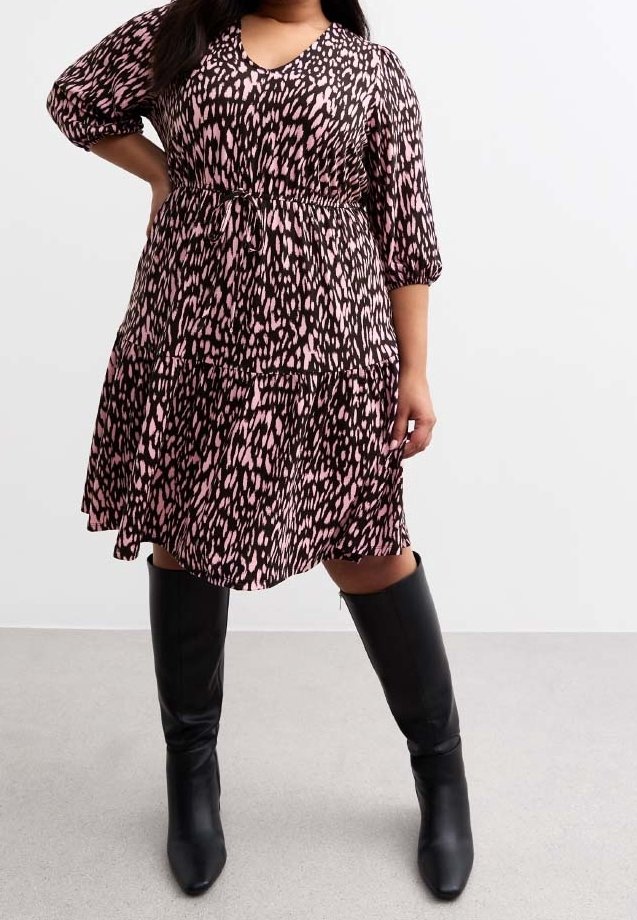 Schwarz und pinkes Tierfellmuster-Kleid mit V-Ausschnitt, Dreiviertelärmel und gestuftem Rock. Kombiniert mit kniehohen schwarzen Stiefeln.