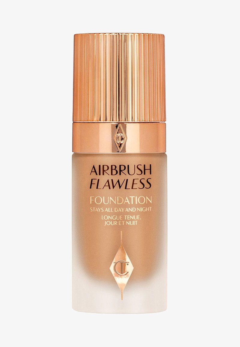 Airbrush Flawless Foundation in a transparent tan bottle with a striped gold cap. Features black text on a white gradient background, detailing use.