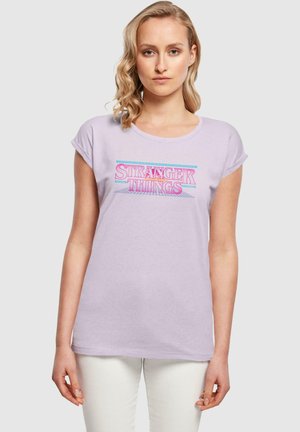Lila Baumwoll-T-Shirt mit aufgerollten Ärmeln, auf dem der Text "STRANGER THINGS" in fetten pinken und blauen Retro-Buchstaben gedruckt ist.