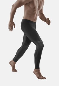 Leggings atletiche nere con un design aderente, caratterizzati da pannelli testurizzati e una vita liscia. Adatti per l'abbigliamento sportivo e per il movimento.
