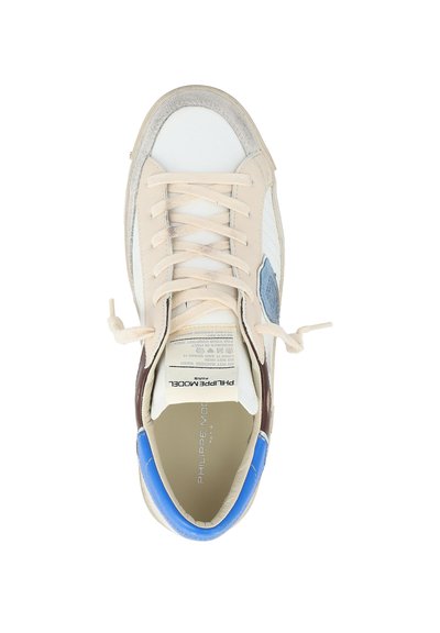 Sneaker beige e bianco con linguetta blu sul tallone, accentuazione laterale marrone, parte anteriore con lacci e marchio "Philippe Model Paris" sulla linguetta e sulla soletta.