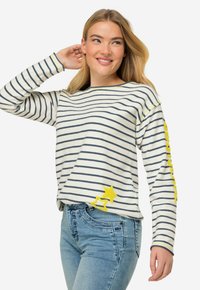 Maglione a righe in crema e blu navy, con accenti di stelle gialle e tessuto testurizzato. Vestibilità ampia con maniche lunghe e colletto a girocollo.