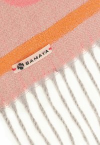 Rosa und orange gewebter Stoff mit Fransenenden und einem genähten Samaya-Brandlabel.