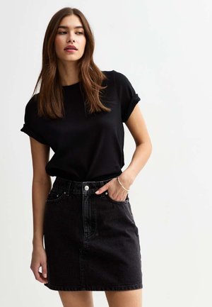 Black short-sleeve top paired with a black denim skirt. The skirt features front pockets and a button closure at the waist.