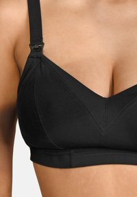 Schwarzer BH aus glattem Stoff mit einem dreieckigen Cup-Design, verstellbaren Trägern und V-förmigen Nahtdetails.