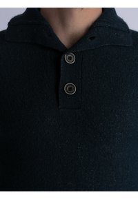 Polo in maglia blu scuro con un finish testurizzato, dotato di colletto ripiegato e due bottoni tondi sullo scollo.