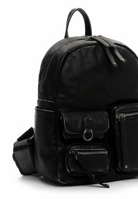 Sac à dos en cuir noir avec compartiments zippés, bretelles réglables et surface texturée. Comprend des pièces métalliques et une poche avant.