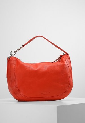 Bolso bandolera de cuero rojo con cierre de metal plateado, forma curva y correa corta, exhibido sobre un pedestal blanco.