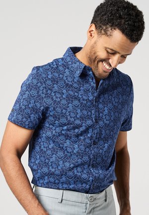 Short-sleeve shirt in navy fabric with a blue floral pattern. Features a collared neck and button closure, offering a smooth texture.