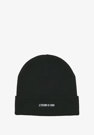 Zwarte gebreide beanie met een omgeslagen manchette, voorzien van contrasterende witte tekst "JJ STUDIO © 1990" geborduurd aan de voorkant. Zachte textuur.
