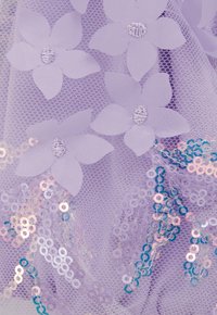 Violeta acs audums ar ziedu aplikācijām un spīguļiem. Ziedu detaļas maigā violetā krāsā, ar daudzkrāsainiem spīdīgiem apaļiem spīguļiem.