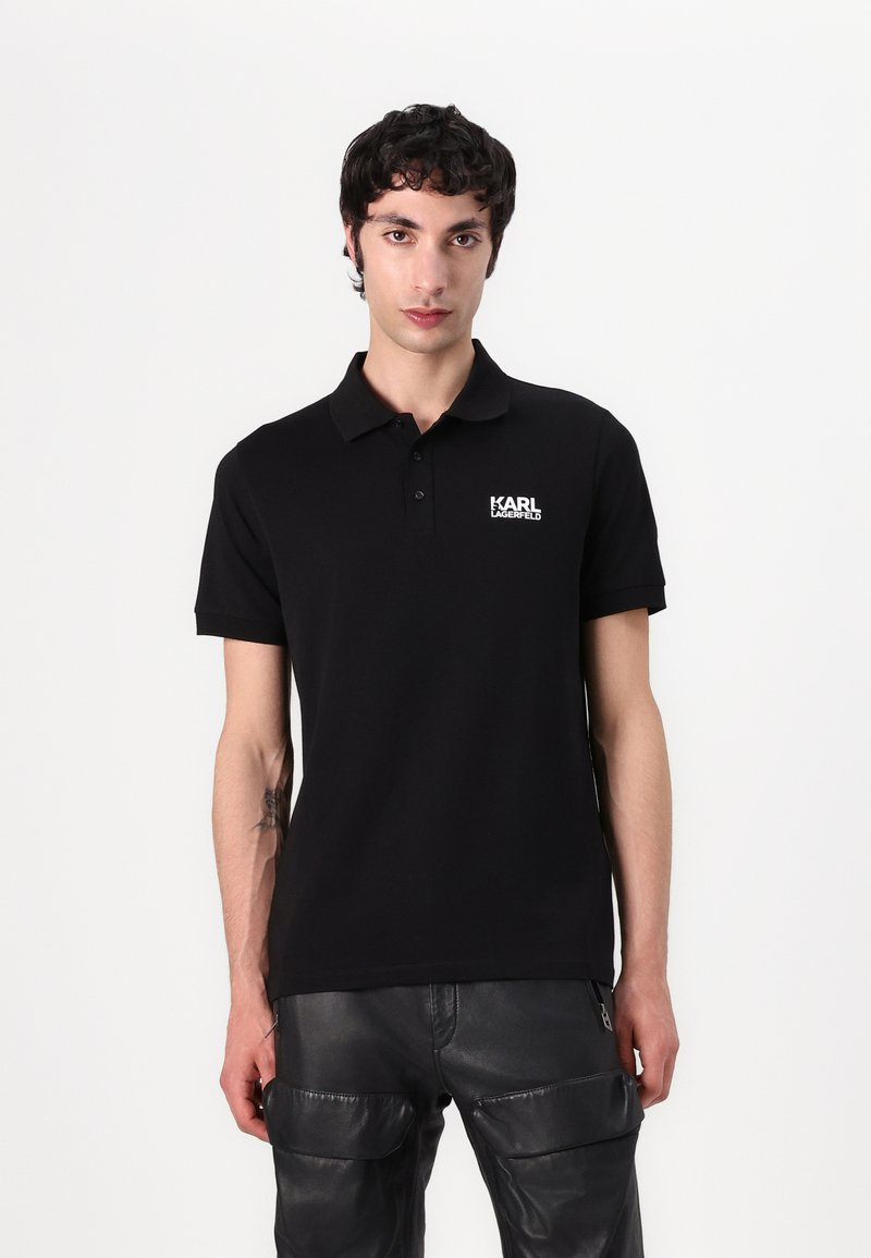 Zwarte polo shirt van zachte stof, korte mouwen, met een kraag. Bevat een wit "KARL LAGERFELD" logo op de linkerborst.