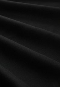 Tela negra con una textura suave, que presenta múltiples pliegues y un acabado mate uniforme. Ideal para diversas aplicaciones textiles.