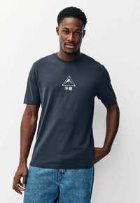 Sötétszürke, rövid ujjú pamut póló, kerek nyakkivágással. Közepén fehér hegy grafikával és japán felirattal.