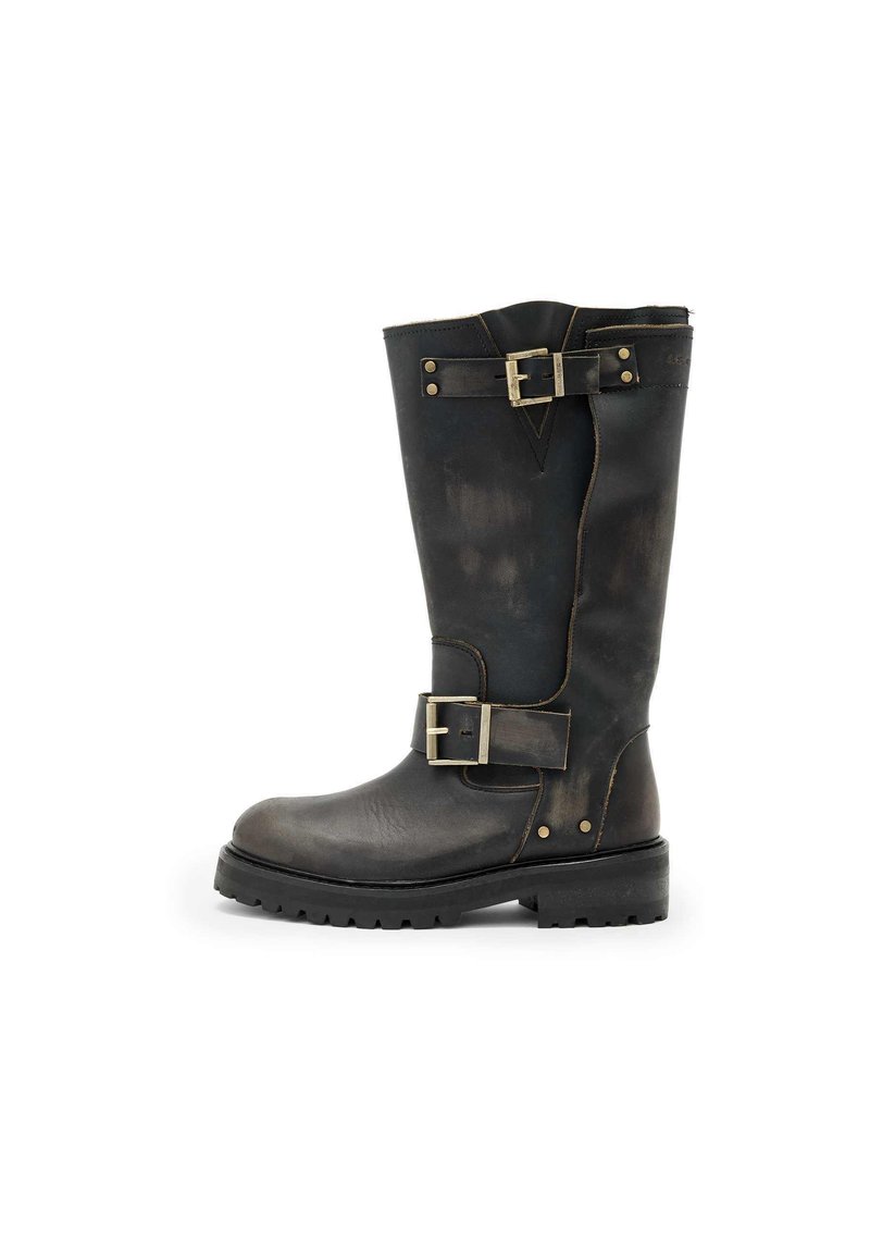 Bota de cuero negro hasta la rodilla con hebillas, superficie texturizada, punta redondeada y suela resistente, diseñada para la durabilidad y el soporte.