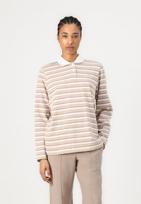 Long-sleeve polo shirt in beige with horizontal stripes in pink and white. Features a white collar and a relaxed fit.