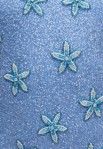 Ανοιχτό μπλε ύφασμα πυκνά καλυμμένο με μικρές διάφανες χάντρες και διακοσμημένο με λευκά και μπλε χάντρες σε σχήμα πεντάφυλλου λουλουδιού.