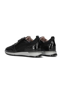 Schwarze Sneakers aus einer Kombination von glänzendem Lackleder und mattem Wildleder, mit einem seitlichen Reißverschluss und einer grauen Gummisohle. Mit subtilen Details akzentuiert.