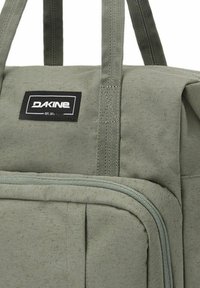 Borsa da viaggio Dakine verde in tessuto con doppie cinghie per il trasporto e tasca anteriore con zip.