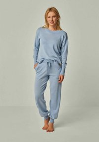 Hellblaues Strick-Loungewear-Set mit einem Langarmoberteil und taillierten Hosen, die einen elastischen Bund und Seitentaschen besitzen.