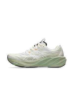 Scarpa da corsa bianca con suola spessa imbottita verde chiaro, tomaia in mesh, lacci bianchi e marchio discreto sul lato e sul tallone.