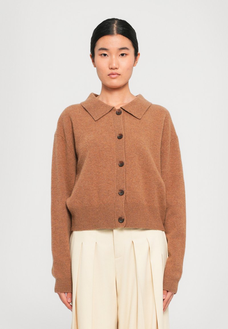 Brun, oversized kardigan med bred krage og seks brune knapper. Har et mykt, teksturert stoff og ribbede mansjetter og kant.