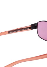 Sunglasses med rosafärgade linser och tunna rosafärgade bågar. Svarta detaljer på gångjärnen. Modellnummer tryckt på den inre armen.