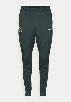 Tamnozelena Nike trenirka s elastičnim pojasom i manžetama. Ima logo Chelsea FC na lijevoj nozi i bijelu Nike swoosh oznaku.