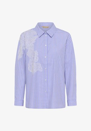 Kék és rózsaszín, kockás ing, fehér virágos csipke hímzéssel a bal oldalán. Klasszikus gallérral és hosszú ujjakkal rendelkezik.