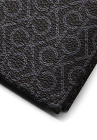 Portafoglio nero in tessuto con motivo in rilievo che presenta lettere stilizzate. Dettagli di cucitura lungo i bordi, leggera lucentezza sulla superficie.