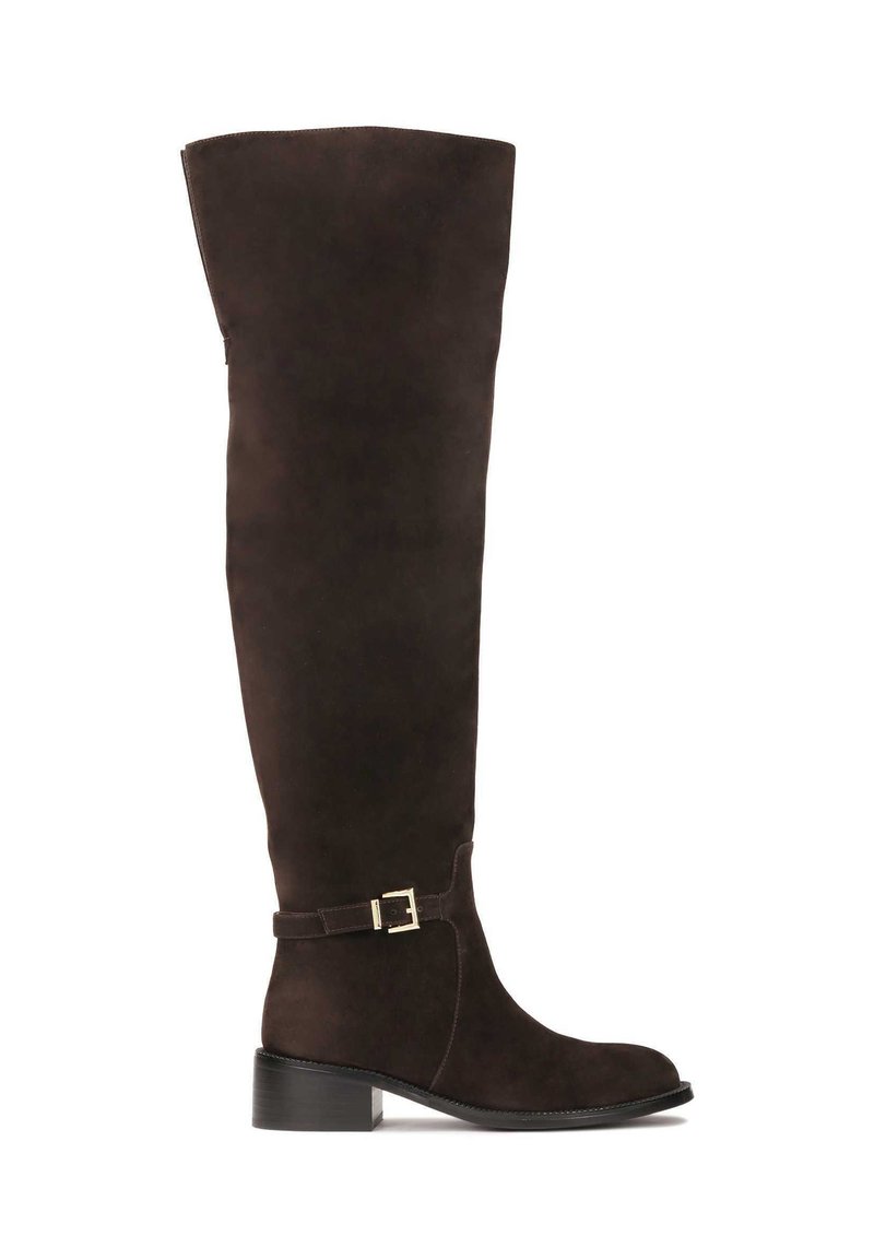 Stivali in suede marrone sopra il ginocchio con punta rotonda, tacco piatto e una cintura decorativa con una fibbia dorata sul gambale.