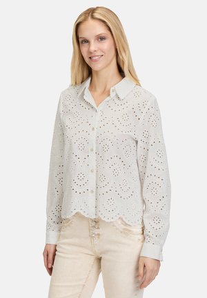 White cotton blouse with button-down collar, eyelet patterns, and scalloped hem; long sleeves, lightweight, semi-sheer texture.