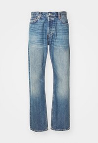 Jeans de mezclilla azul claro con un diseño clásico de pierna recta, acabado desgastado y costuras visibles en toda su extensión. Presenta bolsillos frontales y trabillas para cinturón.