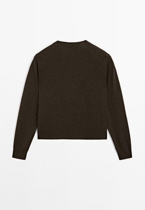 Pull cropped marron avec des manches longues présenté sur un fond blanc, mettant en avant un design simple et minimal.