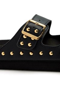 Sandalo in pelle nera con una fascia ampia, dettagli in metallo dorato e una fibbia dorata. La base ha una suola nera texturizzata.