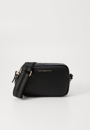 Sac bandoulière en cuir noir de forme rectangulaire, avec un détail logo doré, une bandoulière texturée et une fermeture éclair. Dispose d'une bandoulière réglable.