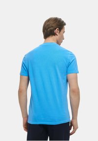 Maglietta a maniche corte da uomo in azzurro chiaro, realizzata in cotone, con scollatura rotonda e una texture liscia. Design semplice senza motivi.