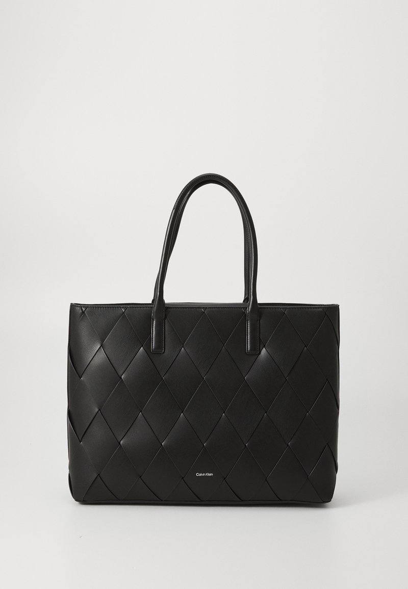 Sac cabas en cuir matelassé noir avec deux poignées et un petit logo Calvin Klein au centre devant.