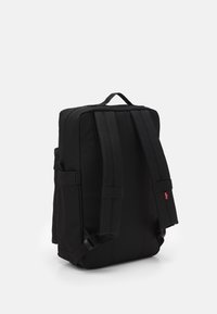 Svart ryggsäck i slitstark tyg, med vadderade axelremmar, ett handtag på toppen och dragkedjestängning med sidofickor för förvaring.