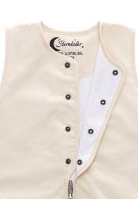 Beige Schlafsack aus weichem Stoff, mit einem Reißverschluss und Druckknopfverschlüssen. Innen ist er weiß. Das Etikett zeigt Marken- und Größeninformationen.